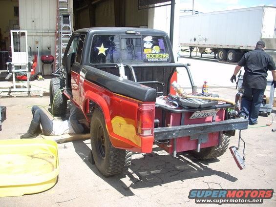 1992 Ford Ranger pickup truck with its rear end being worked on, tools laid out in the bed