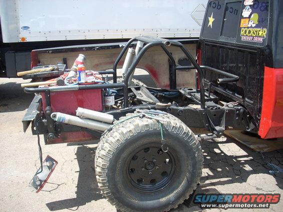 Off-road truck chassis with roll cage, large tires, and exposed suspension components