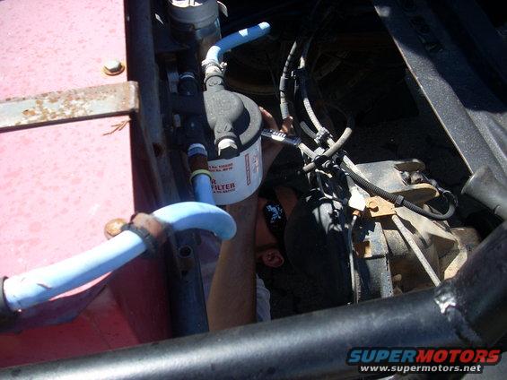 Mechanic working on engine, replacing oil filter