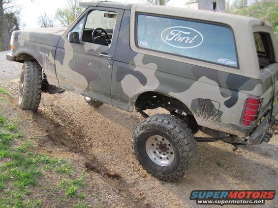 Camouflaged 1995 Ford Bronco 3/4 front view on dirt track