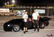 1992 Ford Mustang - Two individuals pose next to a black coupe at what appears to be a nighttime event or race track.