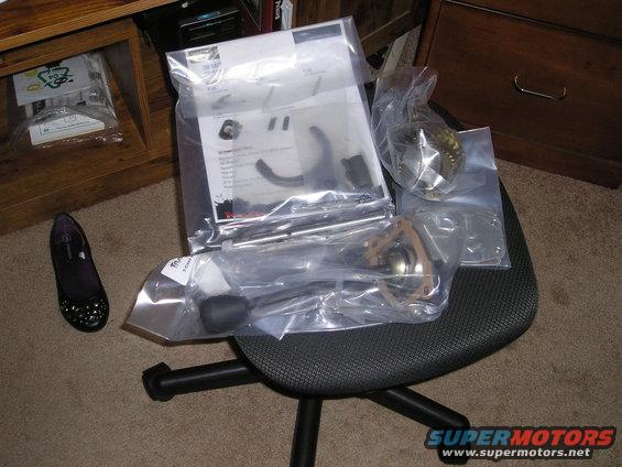 Parts laid out on an office chair, including suspension components and instructions