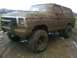 1979 Ford Bronco - This heavily mud-caked 1979 Ford Bronco is shown in a three-quarter front view, likely after off-road use.