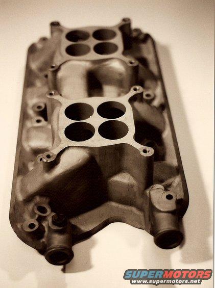 Close-up of an aluminum dual-plane intake manifold with four carburetor mounting holes on each plane