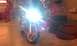 2003 Suzuki SV1000S - A red sport motorcycle is parked in a garage, its headlights shining brightly.