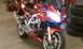 2003 Suzuki SV1000S - This orange 2003 Suzuki SV1000S motorcycle is shown from the front-right in a garage setting.