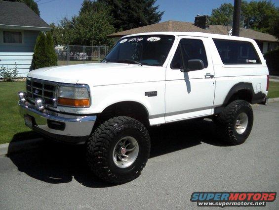 1996 Ford Bronco, lifted with large off-road tires, parked on a residential street