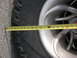 1996 Ford Bronco - A measuring tape is placed across a tire and wheel assembly, showing a portion of the tread and rim.