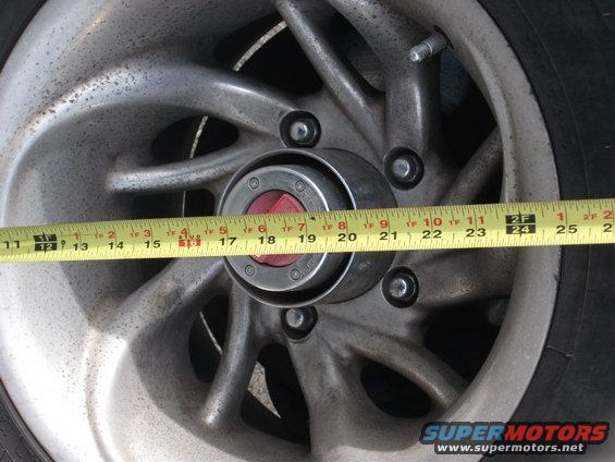Close-up of a wheel hub with a yellow measuring tape across it