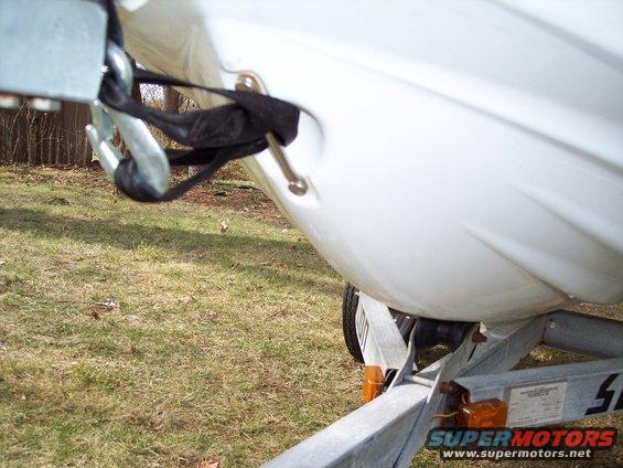 Close-up of a white personal watercraft secured with a strap and hook on a trailer