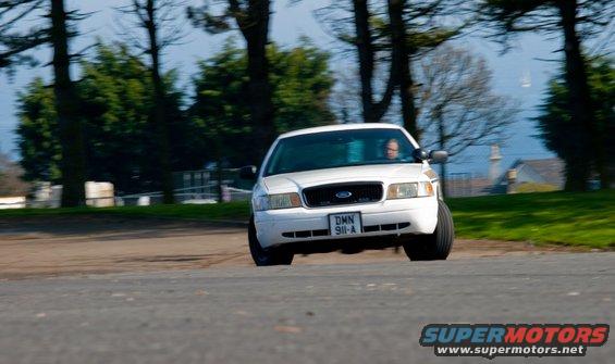 White 2001 Ford Crown Victoria driving on a road