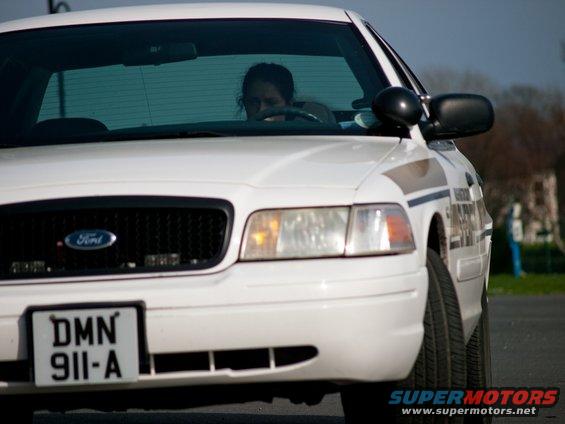 Front view of a white 2001 Ford Crown Victoria police car with a license plate DMN 911-A