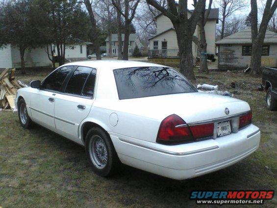 White 1999 Mercury Grand Marquis rear view with chrome trim and wire wheels