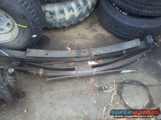 Leaf springs and tires stacked on the ground