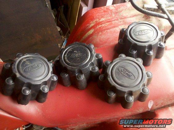 Four black Ford F-250 hubcaps with Ford logos