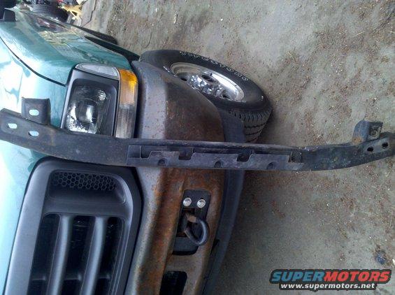 Green truck front end with black bumper bracket and grille. 2003 Ford F-250