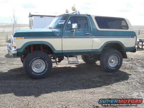 1979 Ford Bronco lifted with off-road tires, two-tone green and cream paint