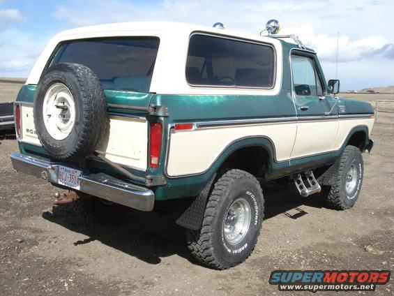 Two-tone green and cream Ford Bronco with spare tire on rear, chrome bumper, and aftermarket steps