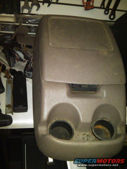 Tan center console with dual cup holders and air vent