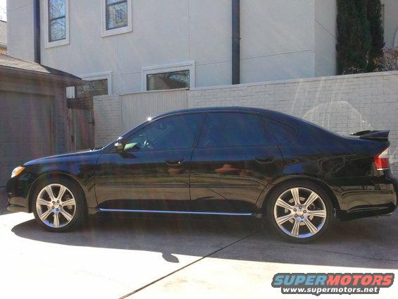 Black sedan parked in driveway. It has tinted windows and a spoiler