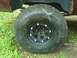 2001 Dodge 1500 - Close-up view of a large off-road tire mounted on a black rim with chrome lug nuts, with the vehicle's fender visible above.