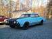 1966 Oldsmobile Cutlass - A light blue 1966 Oldsmobile Cutlass sedan is parked on a gravel lot in front of a shed.