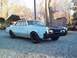 1966 Oldsmobile Cutlass - A 1966 Oldsmobile Cutlass sedan with a two-tone paint job sits on a gravel lot.