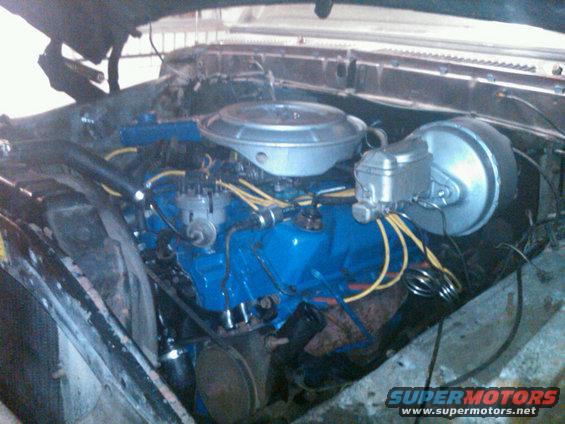 engine bay with blue painted engine block, air cleaner, and brake booster