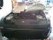 2003 Nissan Xterra - The front of a black car is shown with its hood open, revealing the engine bay and various mechanical parts.
