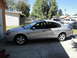 2003 Ford Taurus - A silver 2003 Ford Taurus sedan is parked in a driveway next to a building.