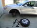 2003 Ford Taurus - Front passenger wheel removed from a 2003 Ford Taurus, with tools laid out for repair.