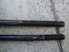 2003 Ford Taurus - Two black threaded rods are shown against a concrete surface. One rod has a smooth shaft, while the other features splines.