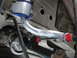 2003 Ford Taurus - Close-up view of aftermarket suspension components, including a silver control arm with blue and red bushings.