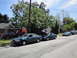 2003 Ford Taurus - A line of sedans are parked along the street, with one green sedan prominently in the foreground.