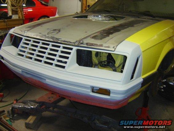 1979 Ford Mustang front end undergoing repair, with yellow fenders and a white grille