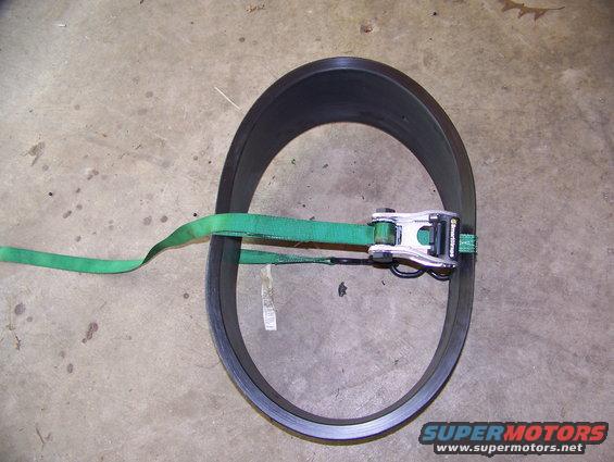 Black ring with green ratchet strap and metal buckle
