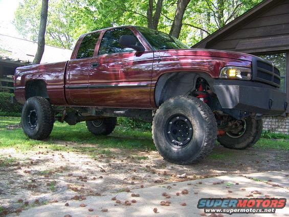 Maroon lifted Dodge pickup truck parked in a driveway