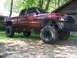2001 Dodge 1500 - This lifted Dodge pickup truck is parked in front of a house with trees in the background.