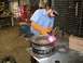 2001 Dodge 1500 - A mechanic is welding a wheel rim in a workshop. The Supermotors logo is visible at the bottom right.