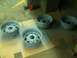 2001 Dodge 1500 - Four bare steel wheels are prepared for painting on a workshop floor.