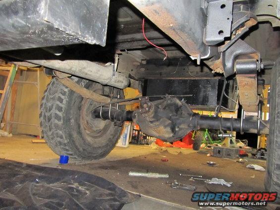 Rear axle and leaf springs of a vehicle, with "SUPERMOTORS" visible on a watermark