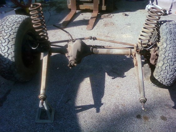 Front axle assembly with tires and coil springs, supported by jack stands