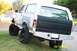 1989 Ford Bronco - This lifted 1989 Ford Bronco features oversized tires and a custom rear bumper, suggesting modifications for off-road use.