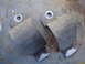 2003 Ford Taurus - Pair of sway bar brackets shown on a weathered metal background.