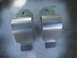 2003 Ford Taurus - Two silver metal sway bar brackets are shown against a textured gray background.