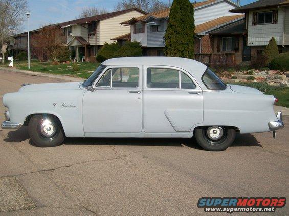 Side view of a light blue 1952 Ford Mainline sedan with "Mainline" script on the fender