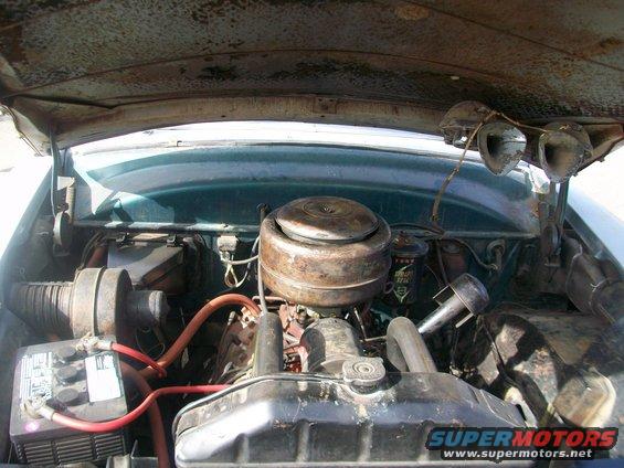1952 Ford Mainline engine bay, green exterior, rusty hood, V8 engine, battery, air cleaner, radiator