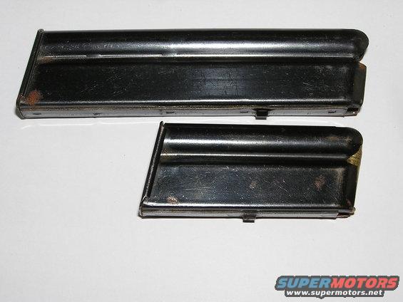 Two black metal gun magazines, one longer than the other, with visible rust spots