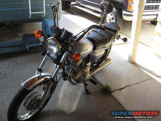 Silver Honda motorcycle with chrome fender, black seat, and orange turn signals