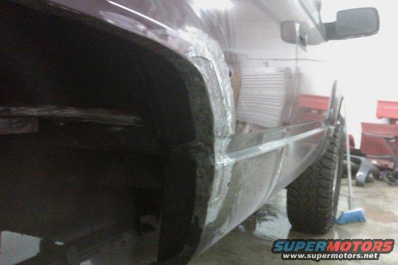 side view of vehicle with rust repair on wheel well and lower body panel